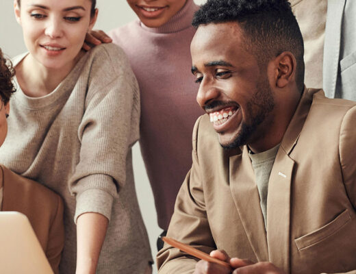Employees looking at a laptop reviewing employee benefits together